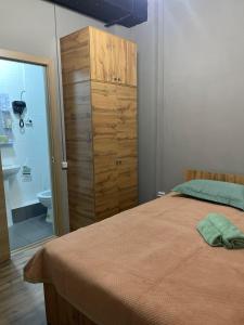 a bedroom with a bed and a dresser and a bathroom at KOCHEVNIK HOSTEL in Almaty