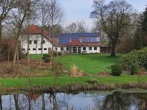 a house with a solar panel on top of a pond at Emily's Garden in Lintrup