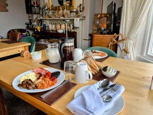 a wooden table with plates of food on it at Kelston Guest House in Weymouth