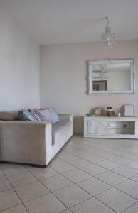 sala de estar con sofá y espejo en Giramondo Guest house en Fiumicino