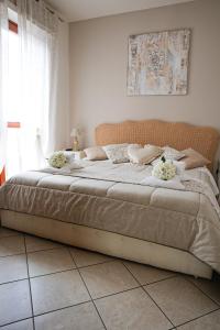 Giramondo Guest house في فيوميتشينو: غرفة نوم بها سرير كبير وعليه زهور