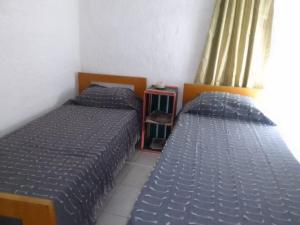 Duas camas num quarto com edredão azul em Los Tatas em Manantiales