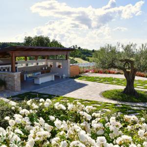 a park with a bench and a tree and flowers at Colle degli ulivi Green Resort in Petacciato