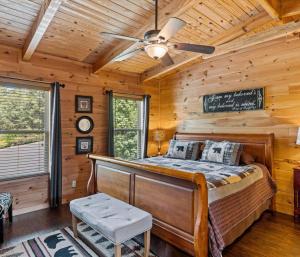 - une chambre avec un lit dans une cabane en rondins dans l'établissement 3br Alpine Retreat With Hot Tub And Theater Room, à Pigeon Forge