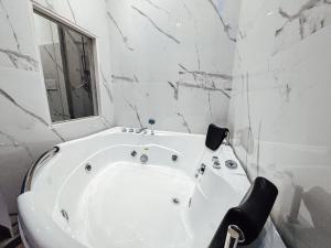 un bagno con vasca bianca e pareti in marmo di Matriosca Suites a Roma