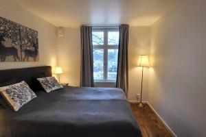 1 dormitorio con 1 cama con 2 almohadas y ventana en Entire beautiful lakefront house, en Västerås