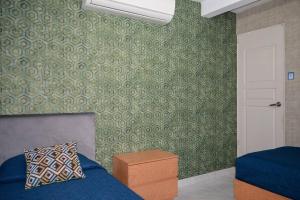1 dormitorio con cama azul y papel pintado verde en Obreros 937, La Alianza Monterrey, en Monterrey