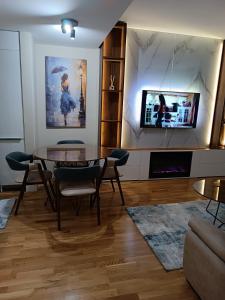 sala de estar con mesa y TV en Anika Luxury apartment at Diamond center, en Skopje