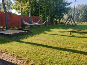 un patio con parque infantil y hamaca en Leśny domek, en Białowieża