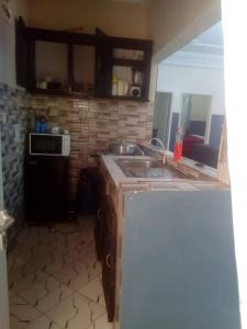 a kitchen with a sink and a microwave at Résidence Sainte Honorine in Yaoundé