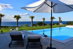 a white umbrella sitting next to a swimming pool at Colle degli ulivi Green Resort in Petacciato