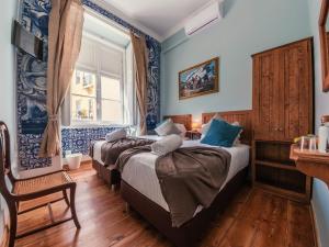 2 camas en una habitación con paredes azules en Casinha das Flores, en Lisboa