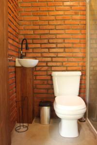 a bathroom with a white toilet and a sink at Vila Sol Cabanas in Lontras