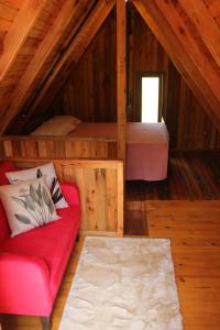 a room with a couch and a bed in a attic at Vila Sol Cabanas in Lontras
