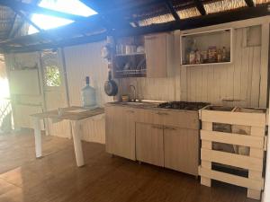 a kitchen with a table and a stove top oven at Punta Arena EcoHostal and EcoFit – Your Eco-Friendly Oasis 02 in Cartagena de Indias