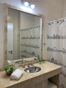 a bathroom with a sink and a large mirror at Luminoso departamento con cochera in San Juan