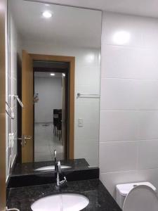 uma casa de banho com um lavatório, um WC e um espelho. em Apartamento em Praia Grande em Arraial do Cabo