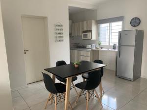 a kitchen with a table and chairs and a refrigerator at Luminoso departamento con cochera in San Juan