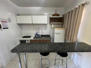 a kitchen with a counter and two bar stools at Lacqua Diroma Loc Caldas in Caldas Novas