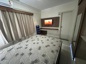 1 dormitorio con 1 cama y TV de pantalla plana en Lacqua Diroma Loc Caldas en Caldas Novas