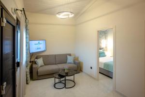 a living room with a couch and a bed at ONAR PALACE in Nea Peramos