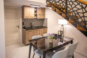 a kitchen with a dining room table with white chairs at ONAR PALACE in Nea Peramos