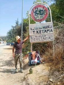a man standing in front of a sign at Welkom ketama hermano in Tlata Ketama