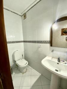 a white bathroom with a toilet and a sink at Welkom ketama hermano in Tlata Ketama