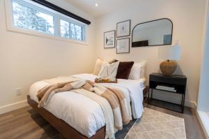 a bedroom with a large bed and a mirror at Mini Chalet Assinie Spa Privé, Nature & Golf in Brownsburg