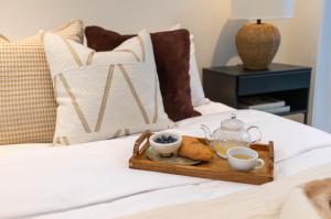 a tray with tea and biscuits on a bed at Mini Chalet Assinie Spa Privé, Nature & Golf in Brownsburg