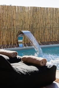 una piscina con una fuente de agua en un edificio en Σπίτι με πισίνα δίπλα στο αεροδρόμιο. en Spáta