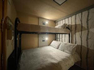 1 dormitorio con litera con sábanas y almohadas blancas en LF LEVEL Sierra Nevada Duplex, en Sierra Nevada