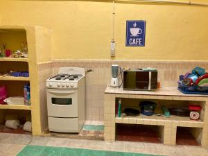 een keuken met een fornuis en een magnetron bij Hostal Republic in Mérida