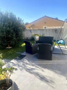 een patio met 2 stoelen en een tafel bij Villa à 10 minutes de Nîmes in Marguerittes
