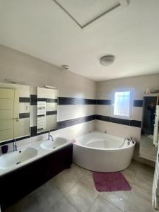 een badkamer met 2 wastafels en een groot bad bij Villa à 10 minutes de Nîmes in Marguerittes