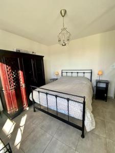 een slaapkamer met een bed en een kroonluchter bij Villa à 10 minutes de Nîmes in Marguerittes