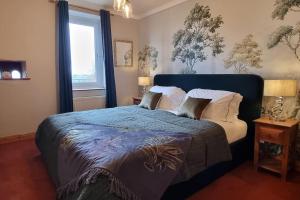 a bedroom with a large bed with a blue blanket at Peaceful Countryside Retreat near Beach/Lakes in Distington