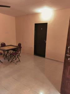 Habitación con mesa, sillas y puerta negra en Nargis Farm Resort, en Vihur