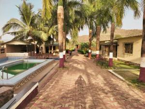 un complejo con piscina y palmeras en Nargis Farm Resort, en Vihur
