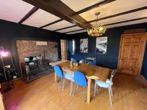 a dining room with a wooden table and blue chairs at Peaceful Countryside Retreat near Beach/Lakes in Distington
