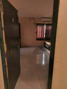 ein leeres Zimmer mit einer Tür und Fliesenboden in der Unterkunft Nargis Farm Resort in Vihur