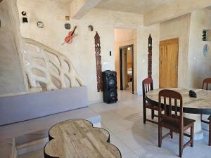 a living room with a table and a wood stove at LE KABOSS in Toliara