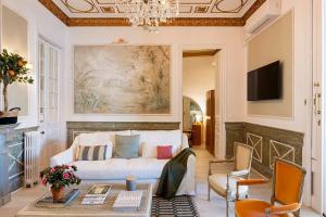 een woonkamer met een witte bank en een kroonluchter bij Placa Catalunya V Charming and Exquisite 5Bd Apartment with Large Balcony in Barcelona
