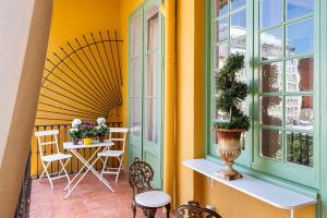 een balkon met een tafel en stoelen en een raam bij Placa Catalunya V Charming and Exquisite 5Bd Apartment with Large Balcony in Barcelona