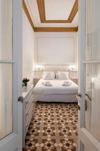 1 dormitorio con cama blanca y suelo a cuadros en Placa Catalunya V Charming and Exquisite 5Bd Apartment with Large Balcony, en Barcelona