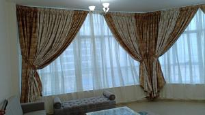 - un salon avec un canapé et de grandes fenêtres dans l'établissement F22,R2 Sea&city view room in three bedroom apartment, separate bath outside, à Ajman