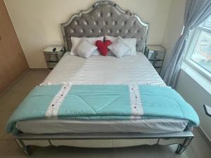 Una cama con dos almohadas y dos corazones. en F22,R2 Sea&city view room in three bedroom apartment, separate bath outside en Ajman 