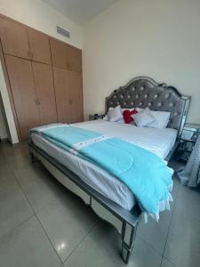 Una cama con una manta azul en una habitación en F22,R2 Sea&city view room in three bedroom apartment, separate bath outside en Ajman 