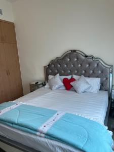 a bed with a blue blanket and pillows on it at F22,R2 Sea&city view room in three bedroom apartment, separate bath outside in Ajman  +10 photos