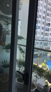 a sliding glass door with potted plants on a balcony at S1-05A11A-Sapphire Hạ Long in Ha Long